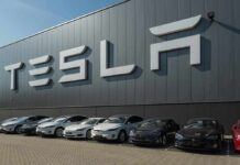 Robotaxi Showdown: Speed vs. Safety Tesla cars parked outside a large Tesla building