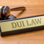 Judge's gavel beside a nameplate on a wooden desk