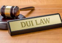 Judge's gavel beside a nameplate on a wooden desk