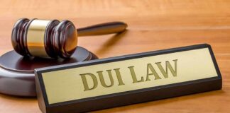 Judge's gavel beside a nameplate on a wooden desk