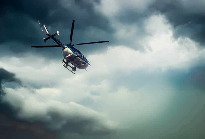 shutterstock_778138441 Police helicopter flying under dark storm clouds