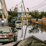 Flooded urban street with abandoned cars and downed power lines