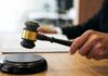 A Flag Protest Became a Deportation Fight Judge's hand holding a gavel over a sound block