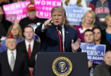Explosive Clash – Then Trump Backs The Ad Donald Trump speaking at a rally podium, pointing toward the audience