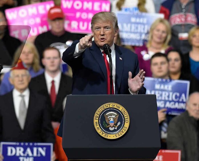 shutterstock_1046190946 Donald Trump speaking at a rally podium, pointing toward the audience
