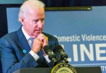 Violence Debate Melts Down – Why Now? man at podium speaking with hands clasped near chin