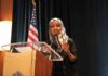 Woman in hijab speaking at a podium