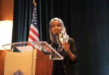Woman in hijab speaking at a podium