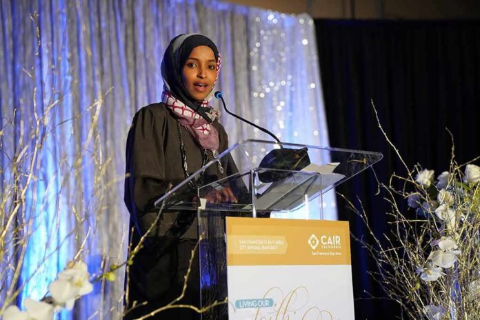 shutterstock_1311573101 Ilhan Omar speaking at a podium on a decorated stage