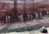 Border Crisis Triggers Trade Shock Soldiers install concertina wire along a tall border fence