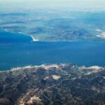 Houthis Push – Trade Lifeline at Risk Aerial view of a coastal strait between mountainous landmasses