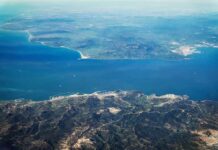Houthis Push – Trade Lifeline at Risk Aerial view of a coastal strait between mountainous landmasses