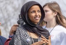 Empty Barrels Allegation Rocks Omar Ilhan Omar wearing a black headscarf at an outdoor event