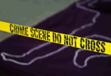 Yellow crime scene tape with body outline in background