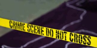 Yellow crime scene tape with body outline in background