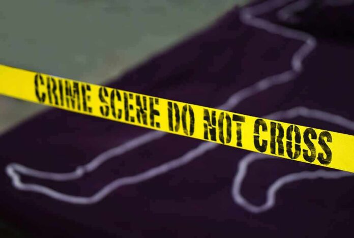 Yellow crime scene tape with body outline in background