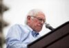 Bernie Sanders speaking at a podium with a microphone