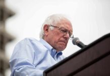 Bernie Sanders speaking at a podium with a microphone