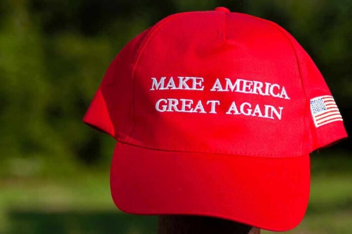 shutterstock_1466940743 Red baseball cap with political slogan and small U.S. flag patch