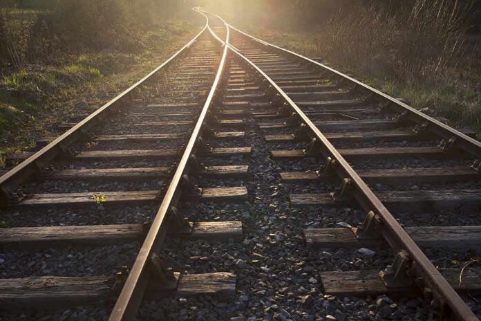 Railway tracks converging into the distance at sunset
