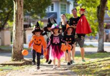 Trump Halloween Flyby Stuns Capital Children in Halloween costumes trick-or-treating with adults on a sunny street