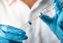 Deadly Measles Wave Jolts Pennsylvania Gloved hands drawing liquid into a syringe from a vial