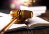 Watchdogs Circle Over ‘Attorney’ Label wooden gavel resting on open law book