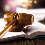wooden gavel resting on open law book
