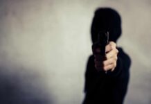 Gunpoint Ambush Rattles LA – Where’s Newsom? person in a hoodie pointing a handgun toward the camera