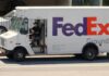 FedEx Ground delivery truck with driver wearing a mask