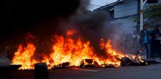 Street fire with burning tires and thick black smoke