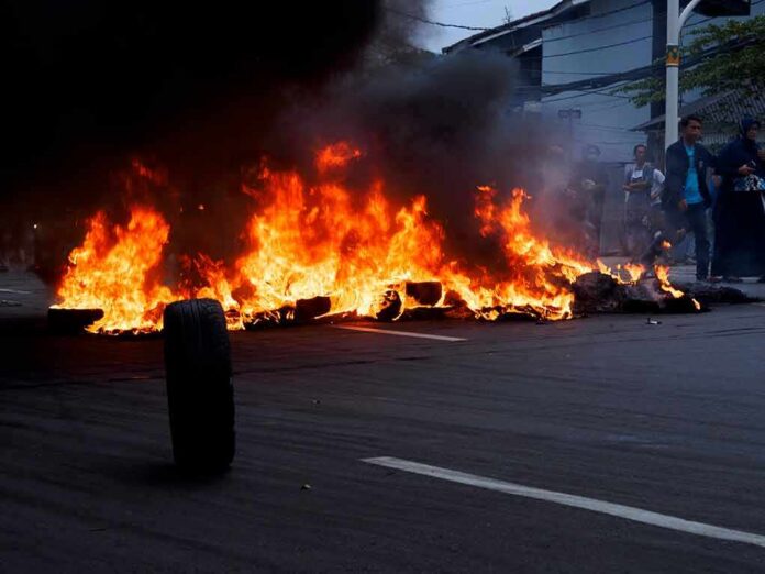shutterstock_1831158025 Street fire with burning tires and thick black smoke