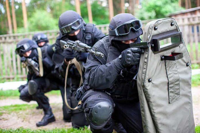 shutterstock_1841092291 Tactical team advancing with ballistic shield and rifles