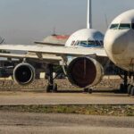Parked passenger aircraft with covered engines on a tarmac