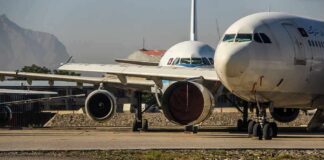 Parked passenger aircraft with covered engines on a tarmac