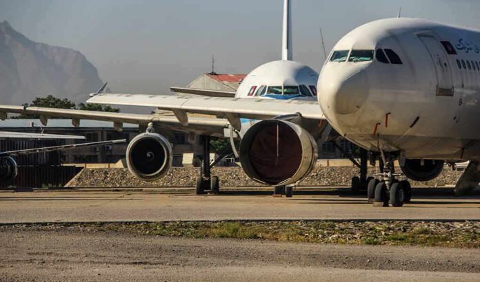 shutterstock_2027869796 Parked passenger aircraft with covered engines on a tarmac