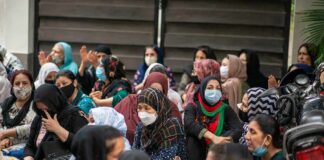 Chuck Howley among a seated crowd of masked women outdoors