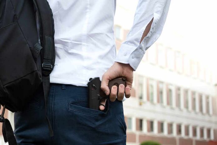 person holding a handgun behind their back near a building