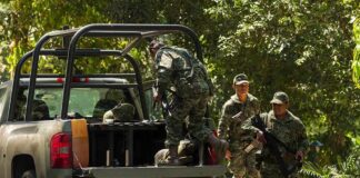 soldiers in camouflage near a military pickup truck