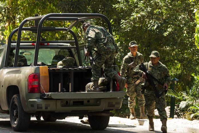 shutterstock_296310842 soldiers in camouflage near a military pickup truck