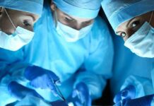 surgeons in blue scrubs performing an operation