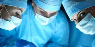 surgeons in blue scrubs performing an operation