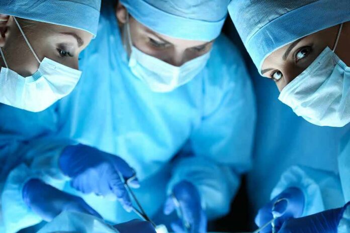 surgeons in blue scrubs performing an operation