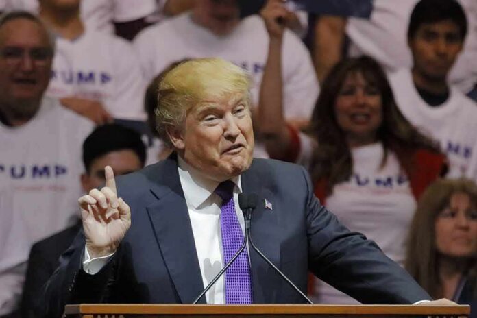 shutterstock_386628055 Donald Trump speaking at a rally, gesturing with one finger raised at a podium