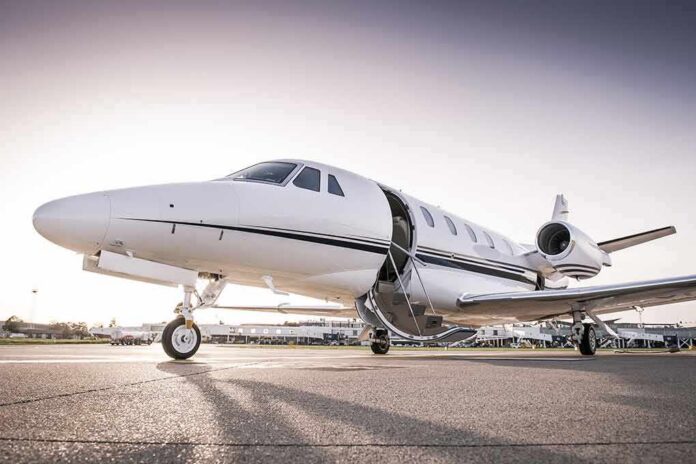 shutterstock_590791349 Private jet on airport tarmac with open door at sunset
