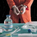 Pentobarbital Drama: Texas Pushes Through Handcuffed person in orange jumpsuit behind medical vials and IV equipment
