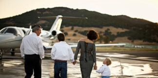 Family walking towards a private jet on a runway.