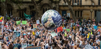 Crowd protesting with signs at a climate change rally.