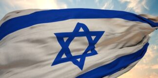 Israeli flag waving against a colorful sunset sky.