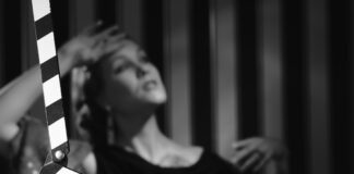 Black and white scene with clapboard and performer.